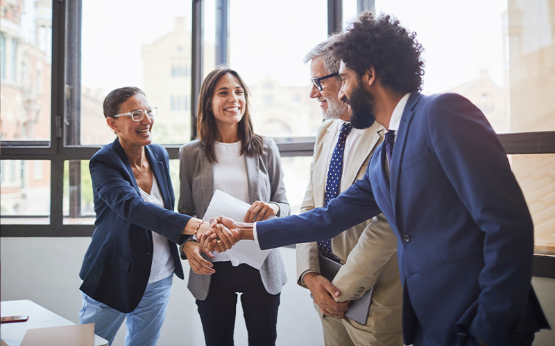 People shaking hands at a meeting